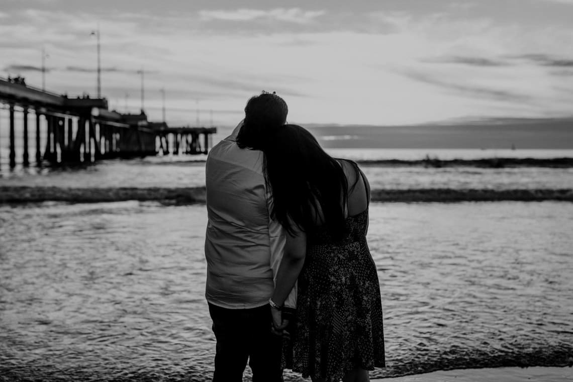 Un couple adulte regarde la mer depuis une plage